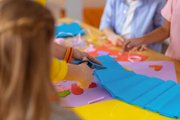 Insegnante indossare braccialetto con le forbici per tagliare la carta blu — Foto Stock