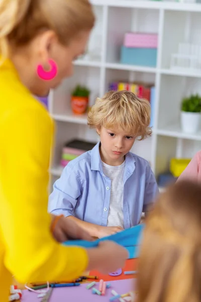 Schoolboy looking at teacher making applied ornament — Stock Photo, Image