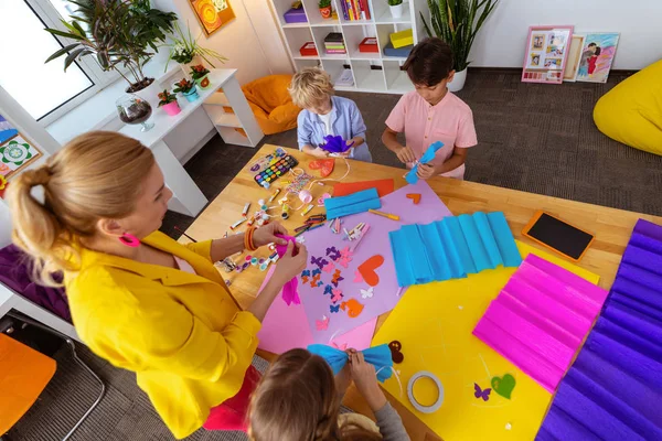 Lärare hjälper skolbarn att göra utskärningar och dekorationer — Stockfoto