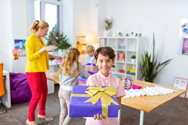 Muchacho mostrando una bonita caja de regalo después de decorarla en clase — Foto de Stock