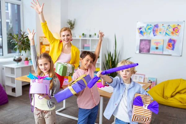 Alunos e professor mostrando caixas presentes após a decoração — Fotografia de Stock