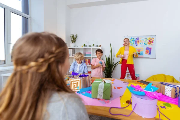 Studentessa guardando il suo divertente insegnante e compagni di classe — Foto Stock