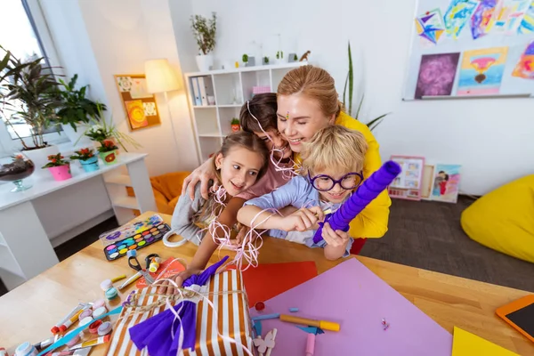 Amante radiante professor abraçando seus alunos diligentes bonitos — Fotografia de Stock