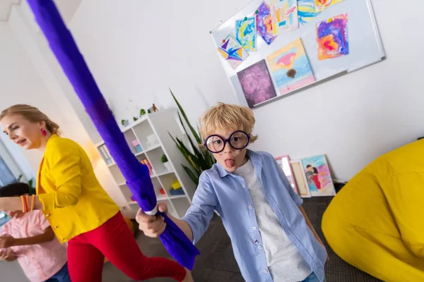 Menino de óculos mostrando língua enquanto se diverte após a aula — Fotografia de Stock