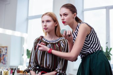 Güzel iyi görünümlü kadın müşterisi için makyaj yapma