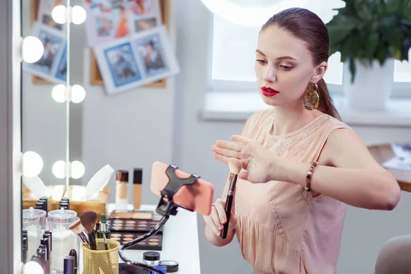 Bonita mujer dando consejos sobre el cepillo de maquillaje —  Fotos de Stock