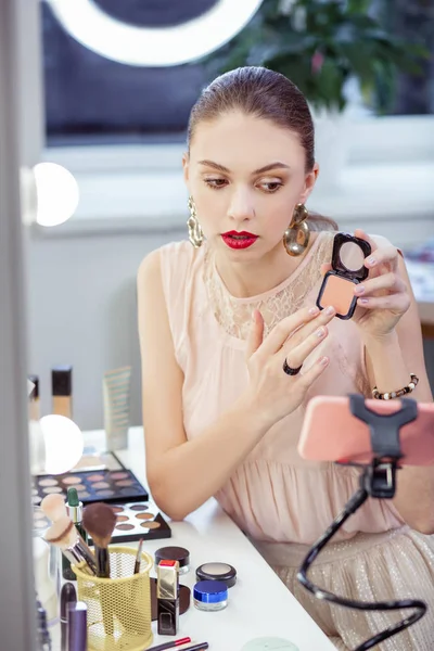 Bastante agradable joven mujer mostrando sus cosméticos —  Fotos de Stock