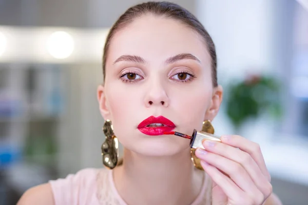 Portret van een mooie aantrekkelijke vrouw zetten lippenstift — Stockfoto