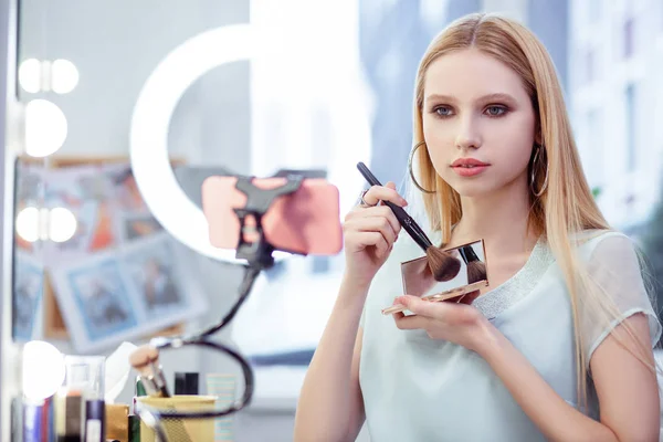 Agradable joven mujer mostrando sus cosméticos en la cámara — Foto de Stock