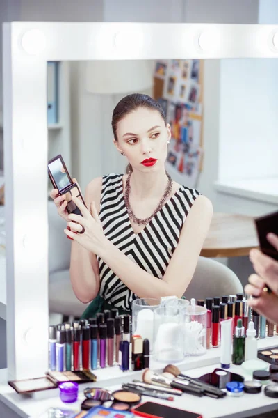 Nice young woman choosing the color for eyeshadow — Stock Photo, Image