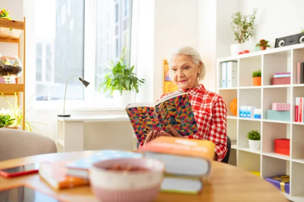 Trevlig positiv kvinna läser en intressant bok — Stockfoto