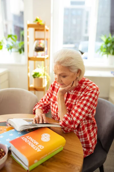 Snygg Senior Kvinna tittar på sidorna — Stockfoto