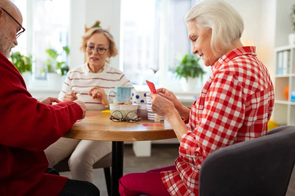 Mooie Senior vrouw houdt haar speelkaarten — Stockfoto