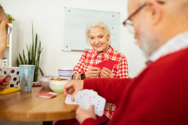 Pleasant senior woman playing with her friend — Stock Photo, Image