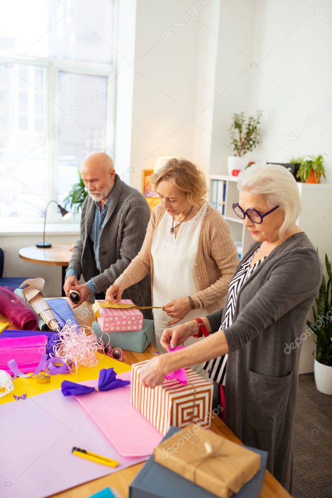 Nice senior people preparing gifts for friends