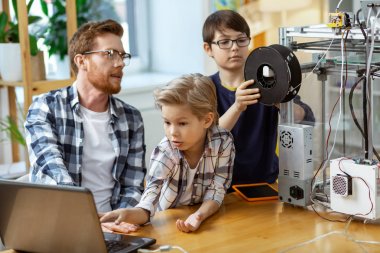 Onun koyu saçlı arkadaşları ise dizüstü ekran gözlemleyerek Expressive sarışın çocuk
