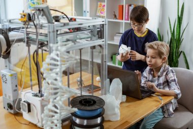 Dizüstü bilgisayar ekranına bakan odaklanmış sarışın genç öğrenci