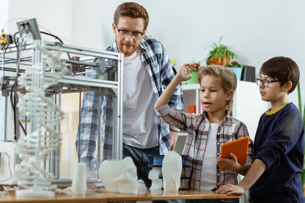 Turuncu tablet taşıyan ve el kaldıran aktif sarışın öğrenci