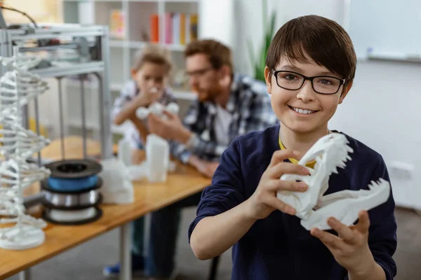 Rayonnant garçon aux cheveux foncés en pull bleu portant un modèle 3D blanc de la tête — Photo