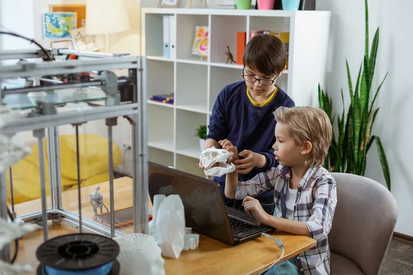 Niños serios sentados en un laboratorio equipado con un portátil — Foto de Stock