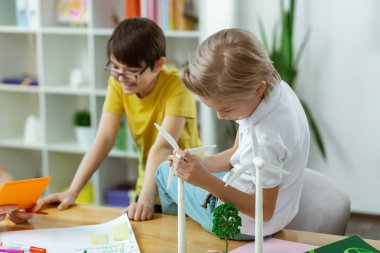 Plastik yel değirmeni mekanizması gözlemleyerek Meraklı sarışın çocuk