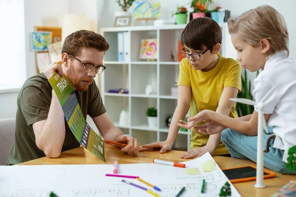 Aufmerksamer kluger Mann zeigt auf die Elemente auf dem Bildungsplakat — Stockfoto