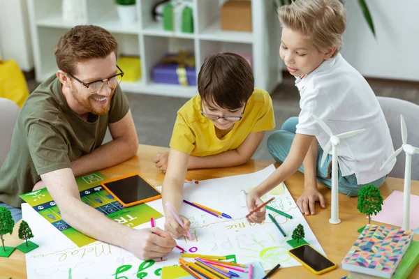 Laughing positive teacher working on colorful poster — Stock Photo, Image