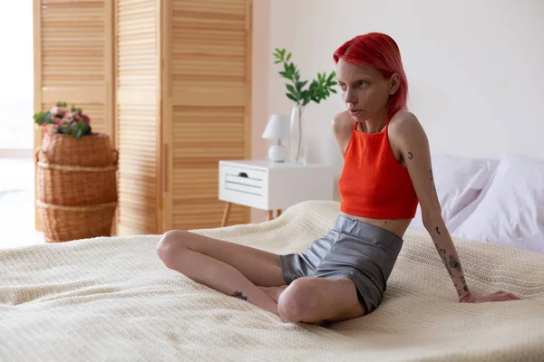 Femme maigre avec boulimie assise sur son lit dans la chambre — Photo