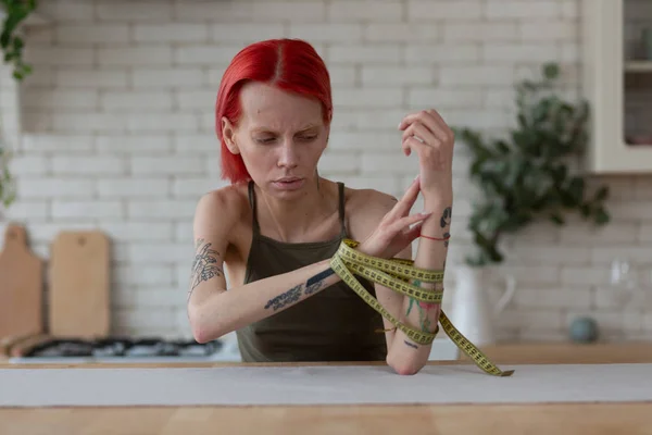 Skinny ruiva mulher tomando fita métrica fora de suas mãos — Fotografia de Stock