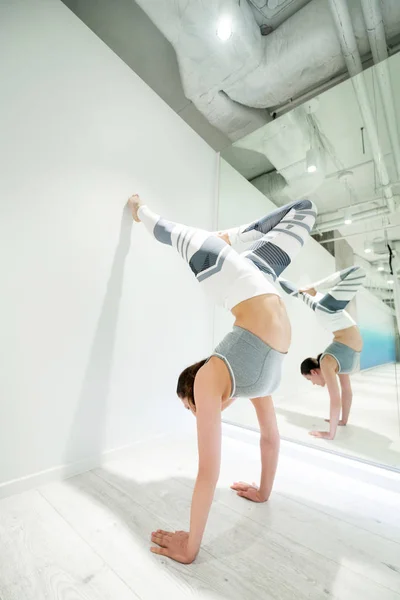 Mujer con leggins blancos y grises practicando el soporte de brazo —  Fotos de Stock