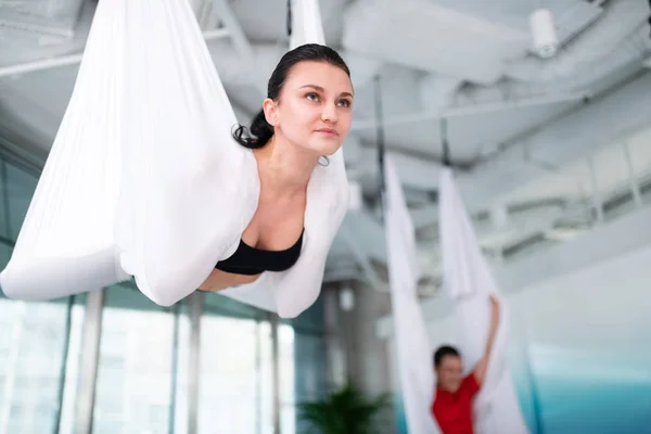 Dark-haired woman wearing black top trying aerial yoga — Stock Photo, Image