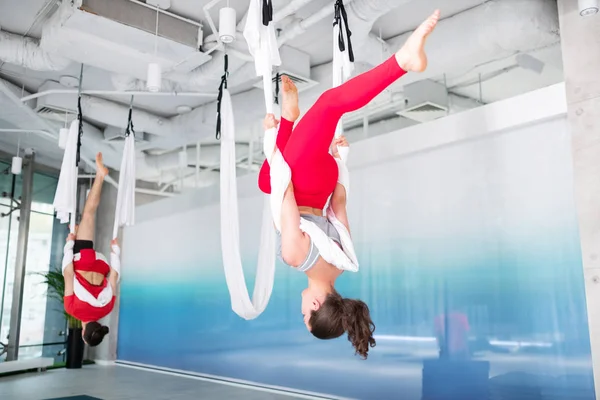 Donkerharige vrouw in rode legging beoefenen lucht yoga — Stockfoto