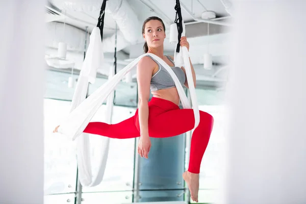 Žena v šedém top pocit vzrušení dělá leteckou jógu — Stock fotografie