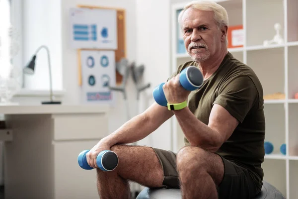 Sério bom homem idoso treinando seu corpo — Fotografia de Stock