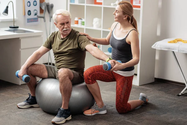 Trevlig åldrad man utbildning på en fitness boll — Stockfoto