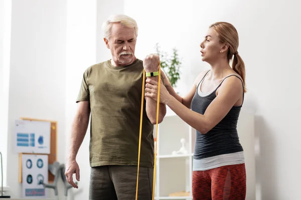 Hombre serio y anciano entrenando sus músculos de la mano — Foto de Stock