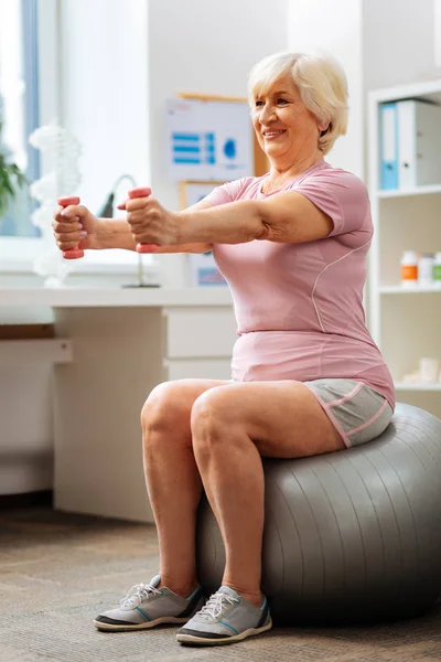 Aktive Seniorin sitzt auf dem Fitnessball — Stockfoto