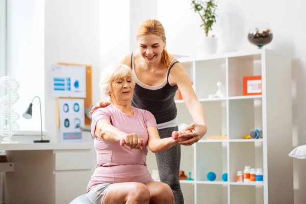 Trevlig Senior kvinna som håller hantlar i händerna — Stockfoto