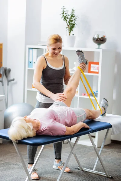 Positiva donna amichevole in piedi vicino al suo paziente — Foto Stock