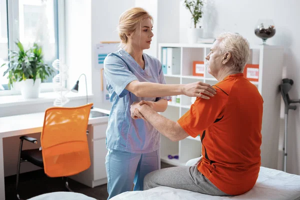 Jovem bonita segurando sua mão pacientes — Fotografia de Stock