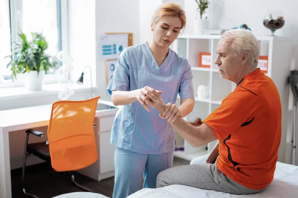 Niza profesional enfermera masajeando sus pacientes dedos — Foto de Stock