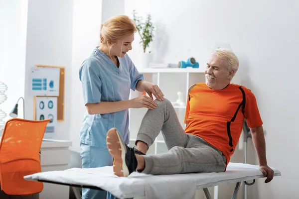 Agradável homem idoso tendo uma massagem no joelho — Fotografia de Stock