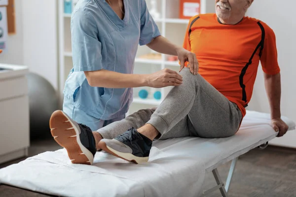 Крупним планом медсестри масажують коліно — стокове фото