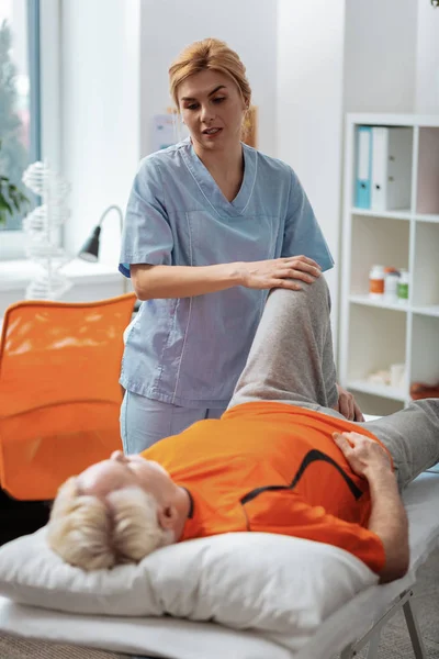 Enfermeira profissional massageando sua perna pacientes — Fotografia de Stock