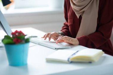Masada otururken klavyede yazan kadını kapatın