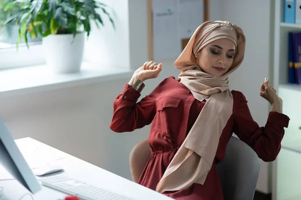 Muslim woman after working on computer for too long
