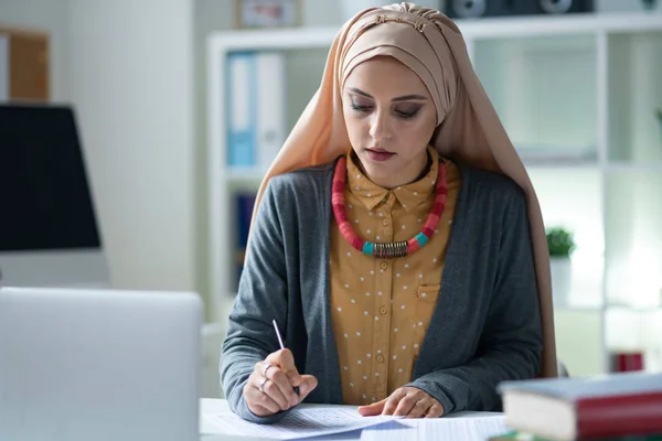 Guru Muslim bergaya mengenakan hijab merasa sibuk mengoreksi tes — Stok Foto