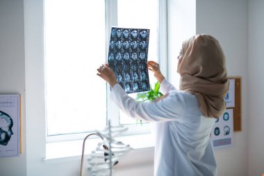 Profesyonel deneyimli doktor x-ray bakarak hijab giyiyor
