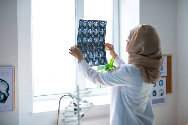 Professionell erfaren läkare bär hijab tittar på röntgen — Stockfoto