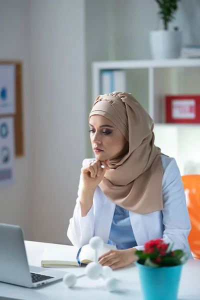 Ahli kimia wanita mengenakan kerudung yang merasa kelebihan beban dengan pekerjaan — Stok Foto